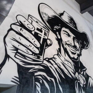 Painting of a cowboy holding a beer.